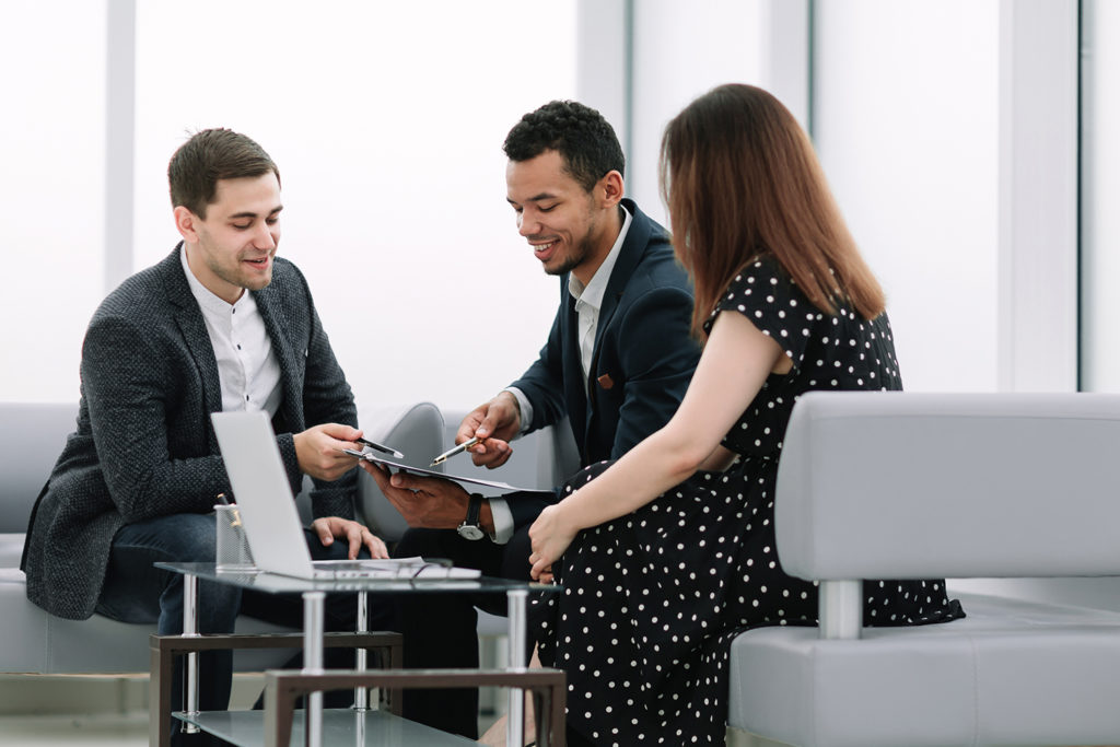 Coworkers talking over a chart in an office